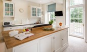 Edenside House - spacious kitchen with island and side entrance door leading into the garden