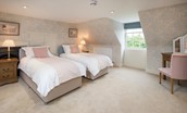 Edenside House - bedroom six on the second floor with zip and link beds, side tables and dressing table