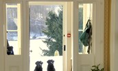 Ellemford Estate - looking out of the front door onto the snowy landscape with two black Labradors sitting by the door