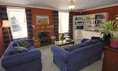 Ellemford Estate - sitting room with wood burning stove, sofas, armchair and TV