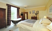 Ellemford Estate - bedroom one with roll top bath, great views, two chest of drawers, wardrobe and TV