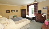 Ellemford Estate - bedroom one with super king double bed, roll top bath, wardrobe, two chest of drawers and TV