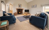 The Rushes - spacious sitting room with cosy wood burner