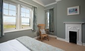 Sandsend - bedroom two with king size bed, wardrobe, decorative fireplace and both west and north facing windows providing sea views