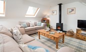 Fisherman's Cottage - sitting room on the first floor with two sofas, wood burning stove, bookshelf, TV and coffee table