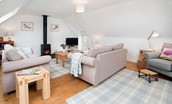Fisherman's Cottage - sitting room on the first floor with two sofas, TV, wood burning stove and armchair