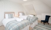 Fisherman's Cottage - bedroom two on the first floor with zip and link beds, side table and chair