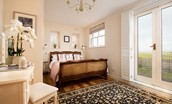 Castle View Cottage - the master bedroom benefits from dual aspect windows and French doors leading to the rear garden allowing light to stream in