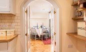 The Craftsman's Cottage - entrance from the dining area to the kitchen through the pretty arched doorway