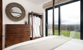 The Oak - chest of drawers with mirror above, open clothes rail and door leading out onto patio