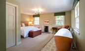 Blackhouse Forest Estate - bedroom one with zip and link beds, free standing bath and decorative log burner