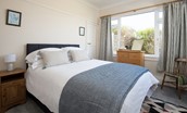 The Fairway - bedroom two with king size bed, side tables, chest of drawers and hanging rail
