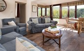 College Cottage - seating area with sofas, armchair and door leading outside