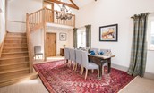 Crookhouse Mill - open-plan living area with dining table seating eight guests and staircase leading to the first floor