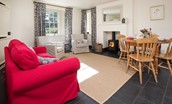 Garden Cottage - open-plan living area with dual aspect views, wood burning stove and dining space for four guests