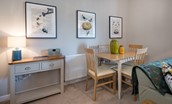 Curlew Cottage - the dining table seating four guests and botanical themed prints