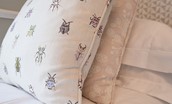 Curlew Cottage - cushions in bedroom two with beetle print