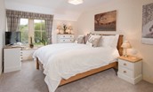 Dryburgh Stirling One - bedroom two with king size bed, side tables, chest of drawers and TV