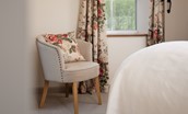 Dipper Cottage - bedroom one with chair and floral furnishings