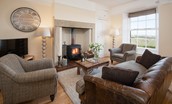 Dipper Cottage - sitting room with inglenook fireplace, wood burning stove, sofa and armchairs