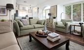 Marine House Cottage - the bright open plan sitting area with comfortable sofa and armchairs