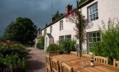The Boathouse - stormy skies above the house and outside dining area