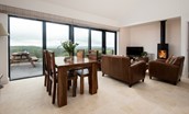 The Willow - bright open plan living area with wooden dining table, seating for four and bi-fold doors leading onto patio area