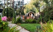 East Lodge Home Farm - pretty garden surrounded by trees with cabin and sauna pod