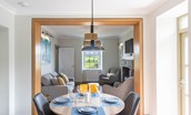 Culdoach Cottage - open plan dining area with cosy sitting room beyond