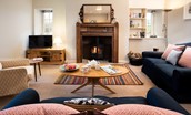 The Bothy at Cheswick - cosy sitting room with seating positioned in front of the wood burner