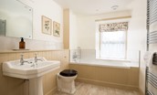 Wark Farmhouse - bedroom one en suite bathroom with bath, handheld shower attachment, WC and basin (1)