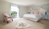 Honeystone House - bedroom four with super king size bed and armchair seating for relaxation