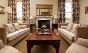 East House - the drawing room with ample seating, fire place with wood burner and double aspect views over the garden