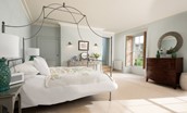 Honeystone House - bedroom six with luxurious four poster king size bed and dressing table, with windows overlooking the side lawned garden