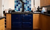 Tutor's Lodge - inky blue AGA framed with vibrant blue tiling is the heart of the kitchen