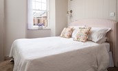 Redcliff - bedroom with double bed and  pretty ticking stripe headboard