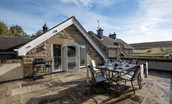 Roundhill Coach House - the large stone flagged terrace area with gas BBQ