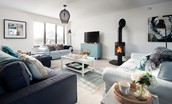 Duneside House - sitting room with modern log burner, comfortable sofas and Smart TV with Blu-ray player