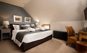 Coach House - bedroom three on first floor with super king bed, bedside tables and dressing table