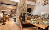 Coach House - dining area with seating for eight guests leading through to the sitting room with wood burning stove