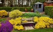 Bughtrig Cottage - the bench seat in the garden surrounded by beautiful planting