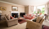 Wark Farmhouse - drawing room with plenty of seating set around the wood burning stove and Smart TV