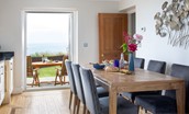 Sea Breeze - kitchen and dining table with French doors leading out to the patio