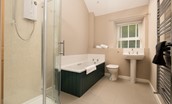 Lyme Grass - family bathroom with a corner shower and separate bath