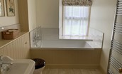 Wark Farmhouse - bedroom one en suite bathroom with bath, handheld shower attachment, WC and basin