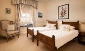 Eslington East Wing - bedroom five with twin beds, accent chair and window seat