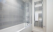 Wild Chive Lodge - the family bathroom benefits from a bath with overhead shower and large heated towel rail