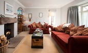 Greengate - sitting room with wood burning stove, two sofas and access to kitchen