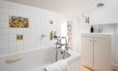 Nook - family bathroom containing bath with hand-held shower attachment, WC, basin and mirror