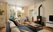 Trouthouse - relaxed sitting room and dining space with a modern log burner and feature pendant lighting